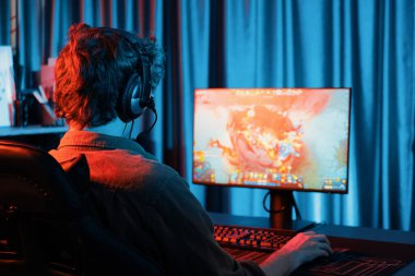Savaş arenasında çoklu oyunlar takımıyla Moba 'da savaşan genç oyun flamasının sunucu kanalı, neon dijital ışık modern odasındaki arka görüntü ile bilgisayar monitöründe kulaklık takıyor. Toplayıcı.