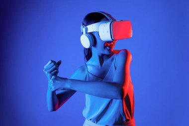 Akıllı kadın, metaevreni, gelecekteki siber uzay topluluğunu bağlayan VR kulaklık takıyor. Sanal lazer kılıcını kontrol eden zarif bir kadın ciddi ciddi dövüş oyunları oynuyor. Halüsinasyon.