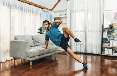 Atletik vücut ve aktif sporcu, sağlıklı vücut çalışma yaşam tarzı konsepti olarak neşeli ev egzersizlerinde kas kazanma egzersizi yapmak için mobilyaları kullanıyor..