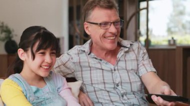 Büyükbaba ve torun birlikte TV 'de ilginç bir eğlence medyası izliyorlar. Eski üst düzey kullanım teknolojisi, genç nesil çapraz nesil ile iletişim kurarak aile bağlarını güçlendiriyor. Uyumsuzluk.