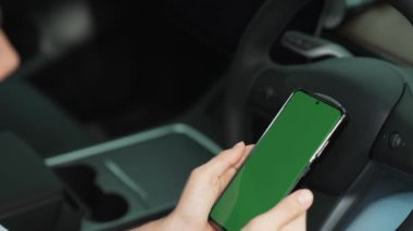 Çevre dostu araba konseptiyle tatil gezisi. EV batarya durumu için boş telif alanı yeşil ekran arabaları tutan sürücü koltuğundaki çevre bilinci olan genç çift. Yükselt