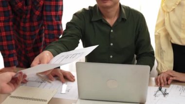 Akıllı mimar ve güvenlik mühendisi, mimari belge, ölçüm araçları ve ahşap blokların modern ofiste etrafa saçıldığı masa planlarını tartışıyor. - Yakın çekim. Tanımlama.