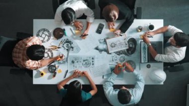 Mühendisin, toplantı masasındaki türbin motorunu ekipmanla gösteren üst düzey görüntüsü. Profesyonel proje yöneticisinin elektronik jeneratör sistemi hakkında konuştuğu ve tartıştığı hava görüntüsü. Hizalama.