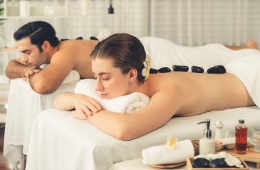 Lüks tatil köyündeki kaplıca salonunda sıcak taş masajı. Gündüz dinginliği ortam, mutlu çift müşterileri bazalt taşı masajının keyfini çıkarıyor. Rahatlatıcı bir sıcaklıkla vücudun üzerinde süzülüyorlar. Sessiz.