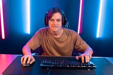 Kazanmak için çevrimiçi oyun oynayan akıllı flama makinesinin sunucu kanalı, neon ışıklı odada seçilen takım yarışması için izleyicilerle birlikte canlı yayında canlı yayında kulaklık takıyor. Bireysel.