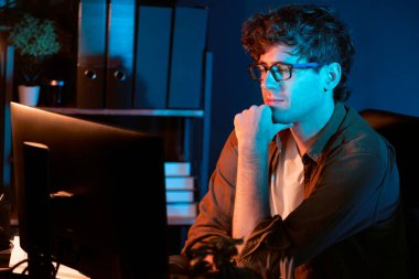 Genç işadamı, Neon Light Modern Ofis 'te yaratıcı bir başlangıç projesi için bilgisayara odaklanıyor. Düşünüyorum da, pazarlama ağı yaratıcıdan pazar kanalı tasarım konseptine çevrimiçi planlama. Toplayıcı.