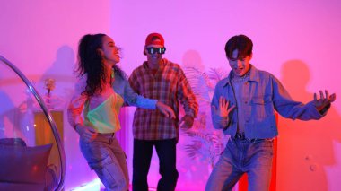 İspanyol hipster renkli kıyafetler giyer ve serbest stil müziğe el sallar. Profesyonel break dansçı neon ışıklarıyla ve modern stüdyo arkadaşlarıyla coşkuyla dans ediyor. Mutluluk.