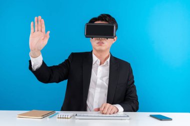 Asyalı işadamı dokunmatik ekran hologram monitörünü fütüristik metaevrende analiz ederek yenilik teknolojisi iş dünyası sanal gerçekliği mavi telif alanını izole ediyor. Entrika.