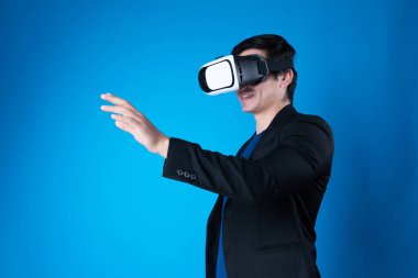 VR kulaklık takan profil işadamı, sanal gerçeklikte mavi arkaplan fütüristik teknolojisini izole eden ilginç verilerle slayta dokunarak metaevren aramasını bağlamaya çalışıyor. Entrika.