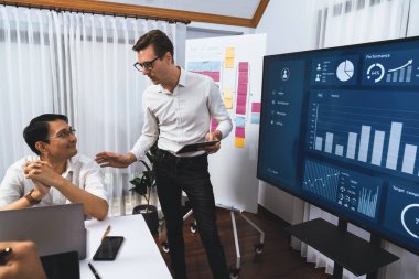 Ofiste sunum ya da analist ekibiyle toplantı odasında mali verileri analiz etmek için BI Fintech 'i kullanmak. İş adamları stratejik planlama için TV ekranında BI gösterge panelini inceliyor.