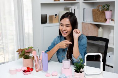Genç, güzel Asyalı kozmetik makyaj ruju matte pastel rengini modern odadaki sosyal medyada kol testi tanıtımında en çok satanlar listesinde gösteriyor. Taktik.