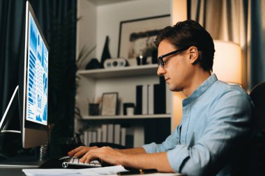 Akıllı iş adamı iş paragrafı dinamik pazarlama analizi planını analiz ediyor. Kağıt kağıtları ve bilgisayar monitörü raporlarını gece evdeki belge verileriyle karşılaştırmak için hazırlıyor. Bireysel.