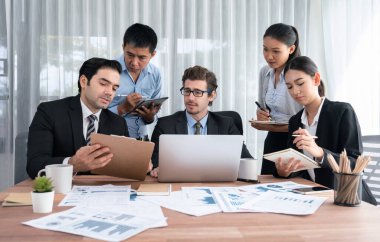 Ofis masasındaki finansal veri raporlarını analiz eden çeşitli bir grup iş analisti. Stratejik pazarlama planlaması için iş istihbarat analizine göre grafikler ve grafikler.