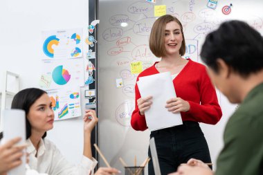 Profesyonel çekici kadın lider, modern iş toplantı odasında beyin fırtınası zihin haritalama istatistikleri ve renkli yapışkan notlar kullanarak yaratıcı pazarlama planını sunuyor. Tertemiz..
