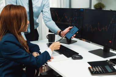 Kâr değeri değeri oranı online web sitesi uygulamasını ev ofisinde analiz etmek için notlar yazan kadınlara telefonda dinamik borsa verilerini gösteren bir işadamı eli kesilmiş. İnfobahn.