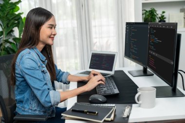 İnternet sitesi uygulamasının kodlama verileriyle birlikte online bilgi yazarak kot gömlek giyen genç Asyalı geliştirici. Güvenlik analizi ile çevrili iki ekran. Taktik.