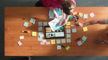 Web tasarımı için birlikte çalışan iş adamlarının üst düzey görüşü. Tasarımcı beyin fırtınası yapan ve web sitesi arayüzü hakkında tartışan ve dijital tasarım ile tablete bakan hava görüşü. Sempozyum.