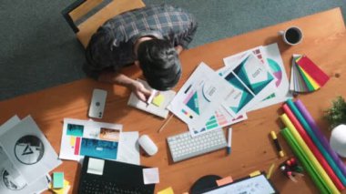 Rengi seçerken akıllı iş adamının müdürü aramasının havadan görüntüsü. Toplantıda ürün için ana tema rengini seçerken ve tasarlarken dizüstü bilgisayara bakan profesyonel iç mimar. Sempozyum.