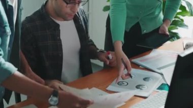 Tasarımcı yazma fikri ekrana bakarken proje yöneticisinin üst görünümü. Akıllı iş adamlarını kapat ve tasarımcı palete bakarken logo tasarımı fikrini açıkla. Sempozyum.