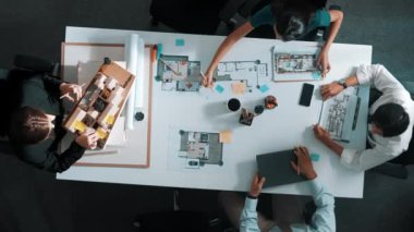 Proje planıyla masaya otururken bir grup farklı takım planlama stratejisi. Zeki iş adamlarının beyin fırtınası ve ev yapımı için birlikte çalıştıklarının en üst düzey görüntüsü. Hizalama.