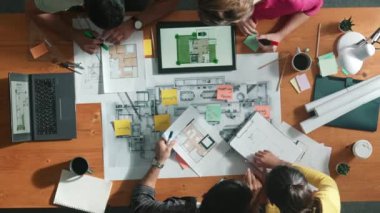 İnşaat mühendisinin planlama ve yazma alanındaki en düşük bakış açısı. Tablet tablet ev tasarımında otururken inşaat tasarımı için birlikte çalışan mimar takımı. Sempozyum.