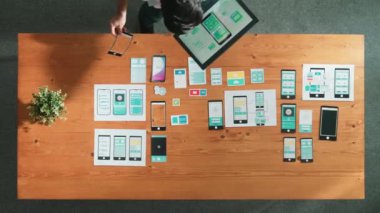 Cep telefonu arayüzü ya da yazılım programı için simge seçerken tablet tutan yazılım geliştiricisinin en üstteki görünümü. Kablo prototipi geliştirmek için Ux Ui tasarımı kullanarak başla. Cemaat.