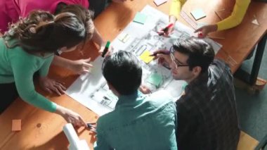Pazarlama ekibi tasarım planlarken akıllı yöneticinin planlama bölümünün en üst görüntüsü. Mimar mühendisin birlikte çalıştığı, fikir paylaştığı ve proje planına not aldığı hava görüşü. Sempozyum.