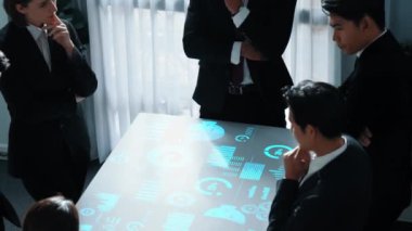 İş adamları grubunun toplantı sırasında veri analizi istatistikleri veya pazarlama yatırım grafiği hologramıyla pazarlama stratejisi hakkında tartışıp beyin fırtınası yaptığına dair üst düzey bir bakış açısı. Müdürlük.