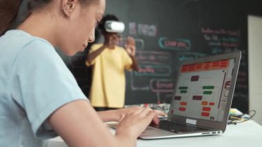 VR kullanan Afrikalı öğrenci meta-dünya ile etkileşime girerken liseli kız el kodlama programını kapat. Zeki çocuk sanal gerçeklik gözlüğü takıyor ve yenilikçi sınıfta video oyunları oynuyor. Öğretim