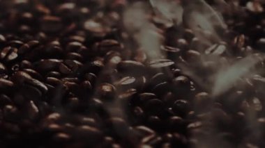 Kahve çekirdeği yığınından çıkan kavrulmuş dumanla taze kahve çekirdeğini kapat. Kokulu ve kokulu sıcak dumanlı sıcak kahve çekirdeğinin makrografisi fasulye yığınından gelir. Yukarıdan aşağıya doğru. Geliştirilebilir.