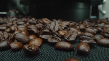 Siyah arka planda kahve çekirdeği yığını. Tasarım ve baskı için yakın çekim stüdyo fotoğrafçılığı. Kahve çekirdeğinin yan görüntüsü siyah arkaplanlı sıcak bir kahve yapmak için hazırlanıyor. Pabulum.