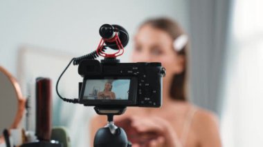 Sosyal medya için güzellik ve kozmetik video içeriği hazırlayan genç bir kadın. Güzellik blogcusu kameraya gülümserken seyircilere ve takipçilere güzellik bakımını gösteriyor. Düzenle