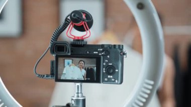 Arka görünüm, kamera ekranında kadın nüfuzunu gizler. Video görüntüleme, video görüntüleme, giysi, sosyal medya ya da blog. Canlı yayın için canlı stüdyo ışıklandırması olan kız canlı yayın pazarlama kaydı