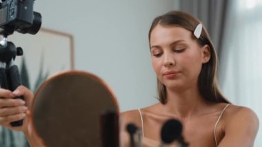 Sosyal medya için güzellik ve kozmetik video içeriği hazırlayan genç bir kadın. Güzellik blogcusu kameraya gülümserken seyircilere ve takipçilere güzellik bakımını gösteriyor. Düzenle