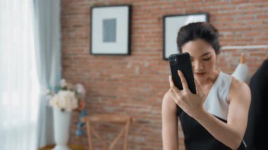 Kadın nüfuzlu kişi canlı yayın yapan video görüntülerini sosyal medya ya da blog üzerinden gözden geçiriyor. Kozmetik stüdyosu ışıklandırmalı mutlu genç kız çevrimiçi pazarlama oturumu yayını için..