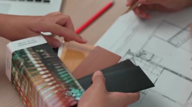 Mimari ekipman kullanan yavaş hareket eden iç mimar bir plan çizerken, iç mimari tasarımcı da müşterilerin talebine göre uygun renk ve malzeme seçiyor. Değiştirilmiş