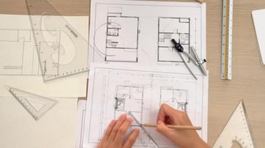 Akıllı mimar ya da akıllı mühendisin ölçüm aracı ve kalem el kullanarak mimari ofisindeki inşaat isabet planı üzerine detaylı bir yazı yazışının videosu. Eline odaklan. - Yakın çekim. Tanımlama.