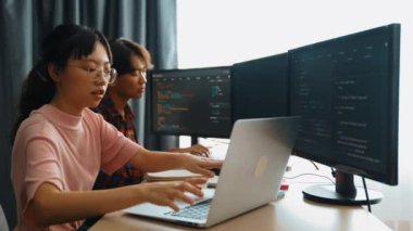 Yavaş çekim arkası yazılım geliştirici mühendisi bilgisayar programlama için birlikte çalışarak hata ayıklama kodunu çözüyor, ofiste monitörde karmaşık algoritmaları çözüyor. Filizlenen