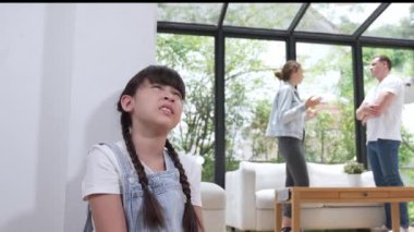 Stresli ve mutsuz genç kız köşeye kıvrılıp kulaklarını kapatarak arka planda ebeveyninin tartışmasını engelliyor. Evde aile içi şiddet ve travmatik çocukluk depresyona dönüşür. Titiz