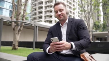 İş adamları, Green City 'deki pazarlama ekibinden gelen satış raporlarını kontrol etmek için telefona bakarken dinlendirici müzik dinlemek için kulaklık takıyor. Happy proje yöneticisi telefon beklerken şarkıya geçiyor. Urbane.