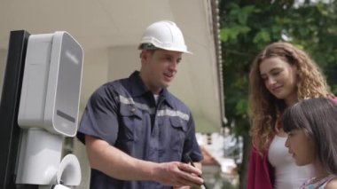 Teknisyen ev EV şarj istasyonu kurar, müşteri akıllı telefonunda şarj durumunu izlemek ve şarj takvimlerini evde ayarlamak için EV uygulamasına hizmet desteği sağlar. Titiz