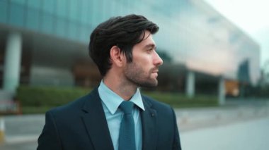 Binada dikilirken kameraya bakan yetenekli bir iş adamı. İş elbisesi giyerken kameraya gülümseyen başarılı adamın yakın çekimi. Mutlu yönetici kameraya bak. İş için. Sevinçli..