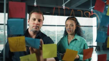 Yetenekli işadamı pazarlama fikrini cam duvardaki proje yöneticisine sundu. Yönetici projeyi yatırımcıya açıklıyor. Zeki iş adamları birlikte çalışıyor, beyin fırtınası yapıyorlar. Yönlendirici.