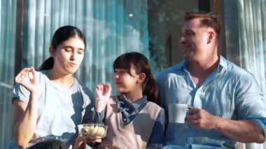 Güzel bir evlilik çifti ve kızı açık terasta yemekli piknik yapıyorlar. Açık hava aktivitelerini kullanan aile, çocuk ve güçlü aile bağı veya ilişkisinin gelişmesini desteklemek için sevgiyi gösterir. Uyumsuzluk.