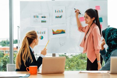 Çok kültürlü çalışma grubu. Farklı etnik kökenden iş kadınları, Kafkasyalı, Asyalı ve Araplardan oluşan bir ekip ofiste dizüstü bilgisayarla birlikte çalışıyor. Çok ırklı takım çalışması konsepti. uds