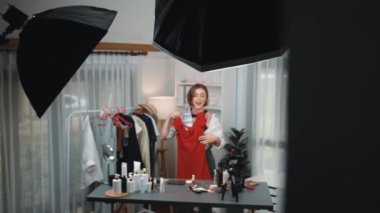 Kadın nüfuzlu kişi video görüntülerini canlı yayınlıyor. Kıyafetler sosyal medyada ya da blogda yer alıyor. Stüdyo ışıklandırmalı mutlu genç kız çevrimiçi pazarlama oturumu yayını için..