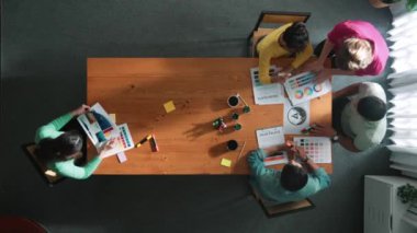 Renk paletinden renk seçmek için birlikte çalışan iş adamlarının en üst görüşü. Proje yöneticisi, logo grafiklerine bakarken pazarlama ekibine tablet kullanarak fikir sunuyor. Sempozyum.