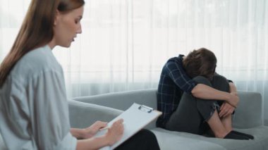 Psikologla ruh sağlığı terapisi gören üzgün travma sonrası stres bozukluğu olan bir kadın. Yaşam sonrası depresyon veya keder. Hayal kırıklığına uğramış genç bir kadın klinikteki duygular hakkında prim psikoloğuyla konuşuyor.