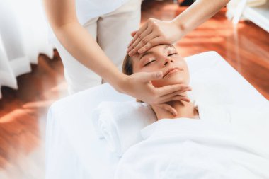 Kafkasyalı kadın stres önleyici kafa masajından ve lüks tatil beldesi ya da otel spa salonundaki modern ışık ortamında yüz güzelliği eğlencelerini şımartmaktan hoşlanıyor. Sessiz.