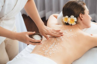 Lüks spa salonlarında sıcak mum ışığında cilt bakımı yaptıran kadın müşteri. Sağlık Spa vücut fırçasında tuz temizleme güzellik tedavisi. Sessiz.